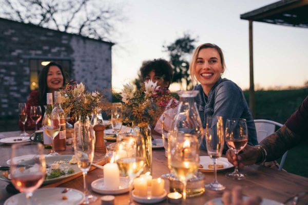 A Small Outdoor Dinner Party With People Smiling