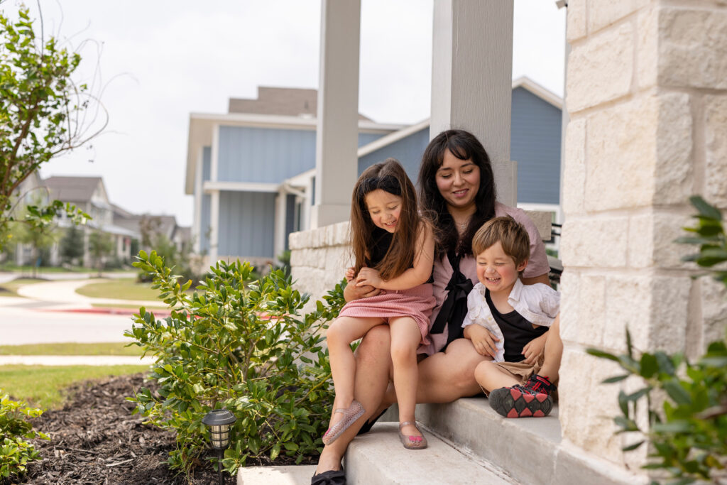Family happily sitting on the porch of their Adelton home.
